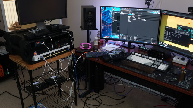 Five VoIP phones strewn across a messy desk all plugged into the Catalyst switch.  All of them are powered on and have booted successfully.