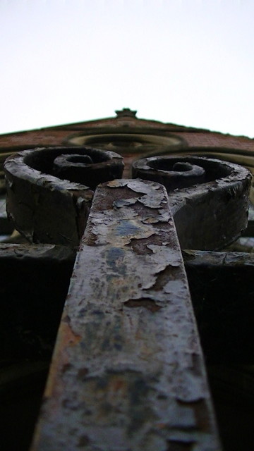 looking up from the iron gate at the south entrance of a red brick church or chapel maybe 