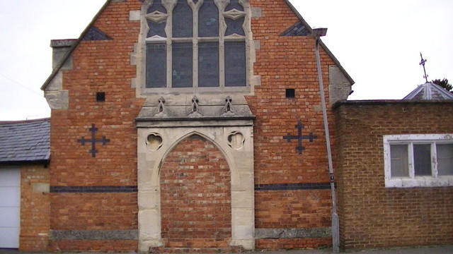 a red brick church possibly victorian with bricked up entrance.