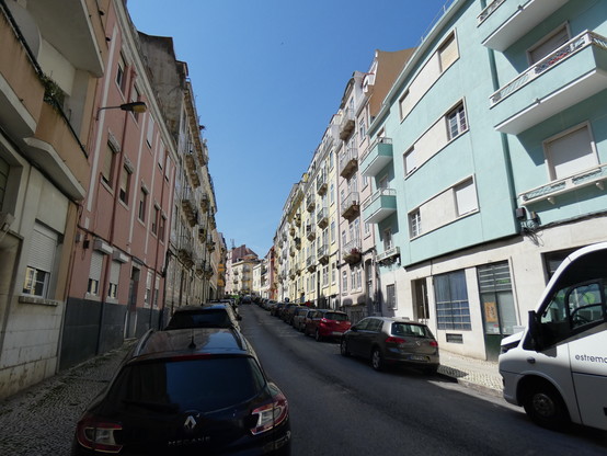 Se ve una calle de subida al barrio lisboeta de Graça con las fachadas de colores