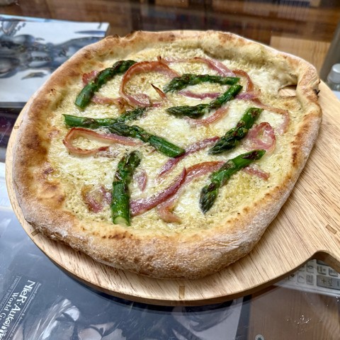 Asparagus cream & pancetta pizza, with a small hole near the border