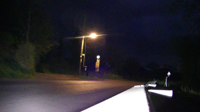 a road at night with street light and road signs