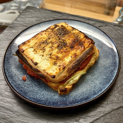 Said croque in a small plate, in all its cheesy glory