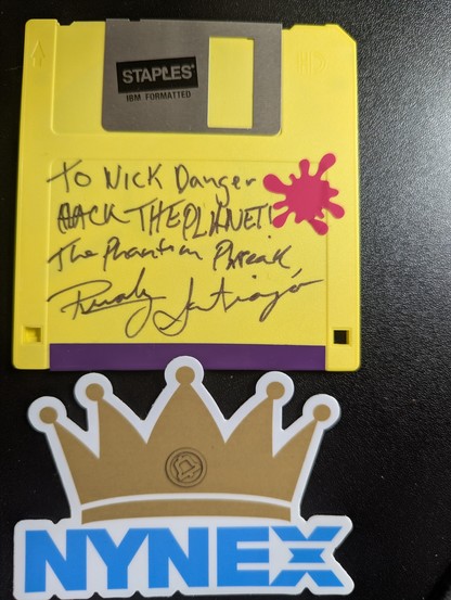 3.5 floppy disk with message and signature of Renoly Santiago, the Phantom Phreak. The H looks like a B in Hack so the message sorta reads Back the Planet