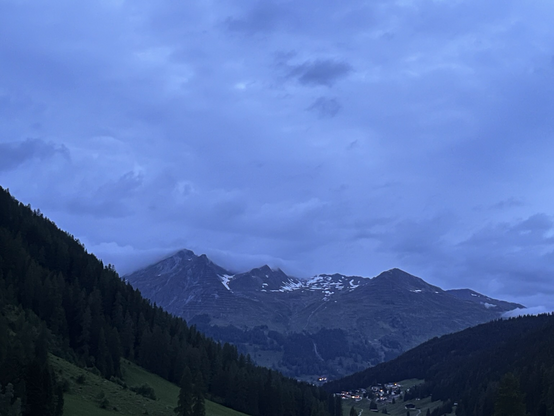 Distant snowy mountains, dark mountainside, large sky