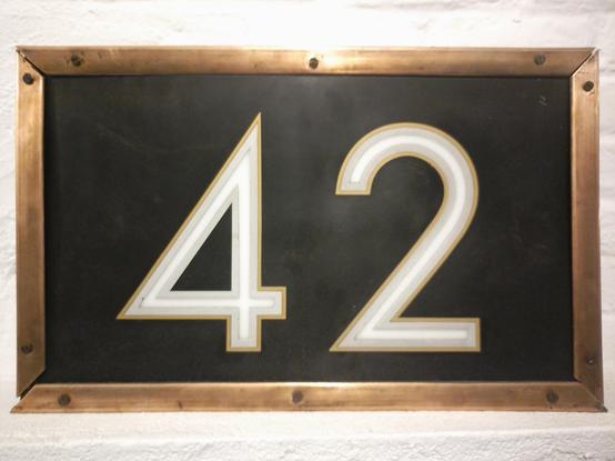 Un cartel del número 42 del portal de la calle Santa Isabel de Madrid. Es de los años 50 y está pintado a mano sobre cristal