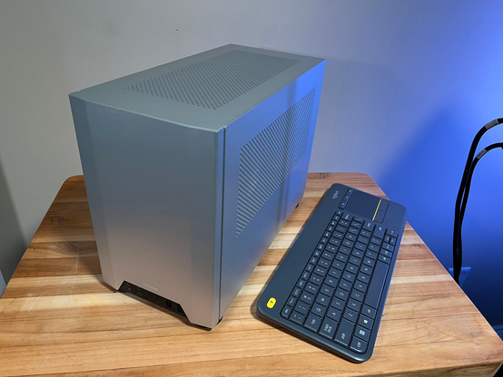 A picture of the front and side of the NCASE M1 V5 case that houses the Steam Machine knock-off.  Beside it is a Logitech K400 wireless keyboard for scale.