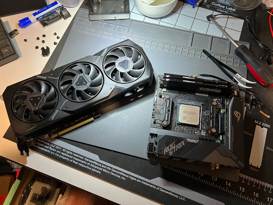 An AMD Radeon 7900XT sitting next to an X570 mITX motherboard with a 5950X socketed in it.