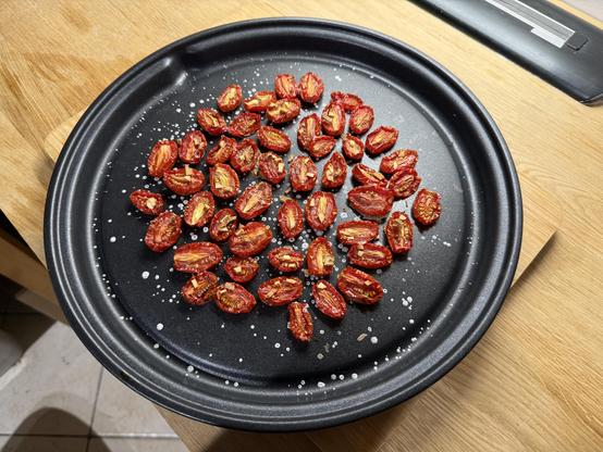 First you take ripe cherry tomatoes, cut them in half and put them sliced side upside on a baking sheet or something. Add garlic and salt. Bake at 150 degrees for an hour. This is what you get.