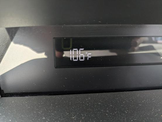Thermostat on a car dash reading 106°F