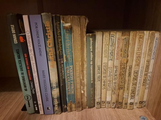 Vemos, quase em close up, uma prateleira de livros de mistério. Há alguns autores como Conan Doyle e Mary Higgins Clark, mas a grande maioria é da Agatha Christie. A maior parte dos livros têm uma aparência bem desgastada e antiga.
