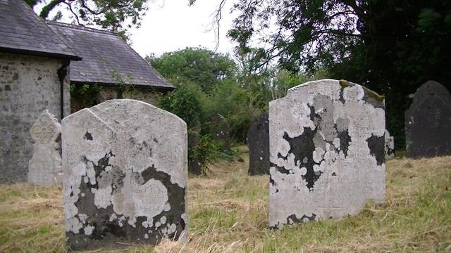 some more beautiful lichen covered gravestones in the same churchyard with the south-east end of the church in the background