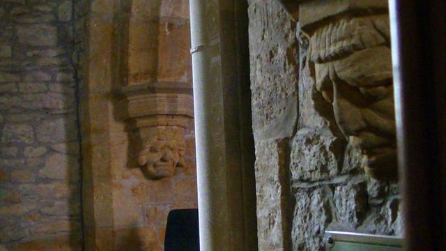 a couple of corbels carrying the arches with grim and glum looking carved faces on perpendicular church walls. the church is at least 12th or 13th century. some parts possibly older.
