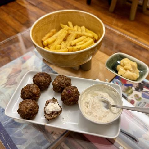 The meatballs served, with a yoghurt based dipping sauce and french fries