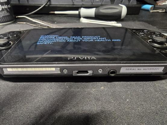 A PlayStation Vita model 1000, with its charging port modified to a USB Type C. The console is turning on, showing that its not dead.
