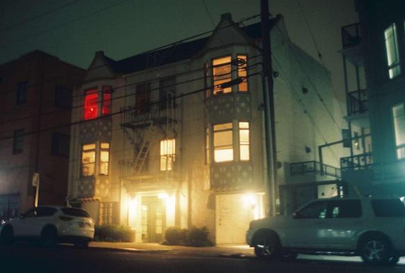 apartments at night, from one group of windows come red light