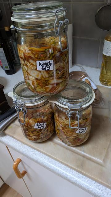 Finished! Photo of three preserving jars filled up to 2/3 with the Kimchi mixture. Each glass has a white label on it that says: Kimchi 6/9