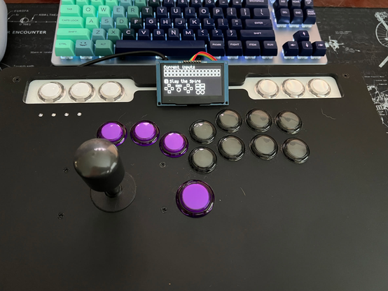 A picture of my custom fightstick with a small display on the top showing it running the _Slay the Spire_ custom profile to allow directional inputs from the joystick and the buttons at the same time.