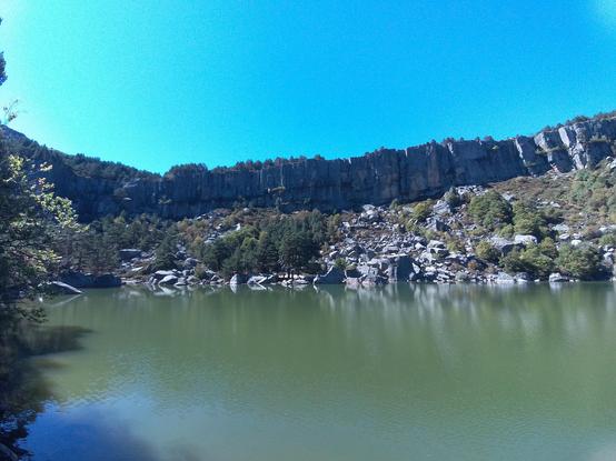 Se ve una laguna rodeada de escarpados montes. En el cuaternario fue un glaciar que formó la laguna y todo el entorno al retirarse.